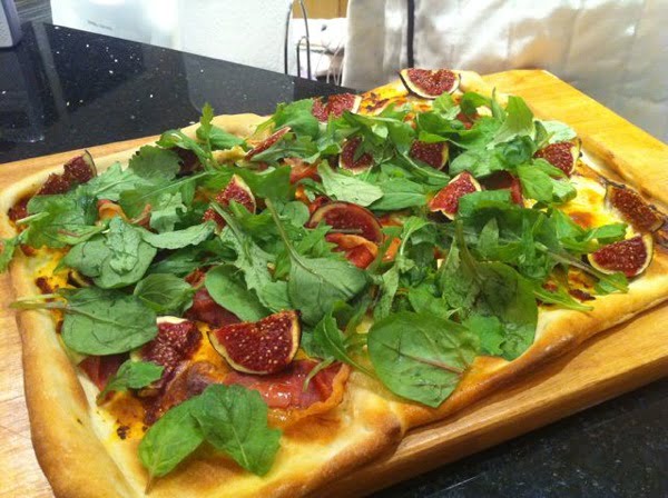Homemade Pizza dough with prosciutto, figs and rocket topping