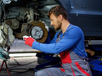 Mechanic checking car brake system in a workshop