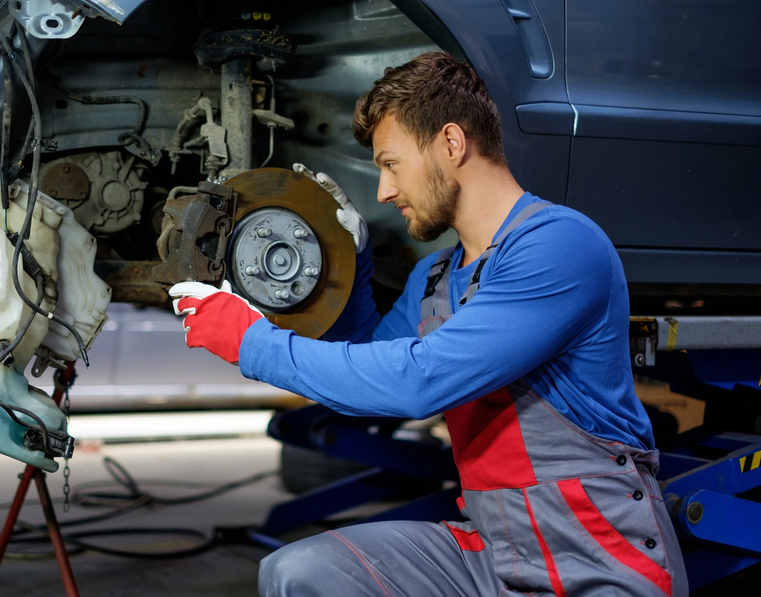 Mechanic checking car brake system in a workshop