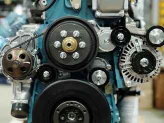 Close-up of working engine of huge industrial machine with rotating shafts inside distribution warehouse or workshop