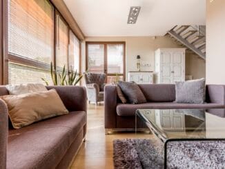 Bright grey living room with two couches and glass coffee table