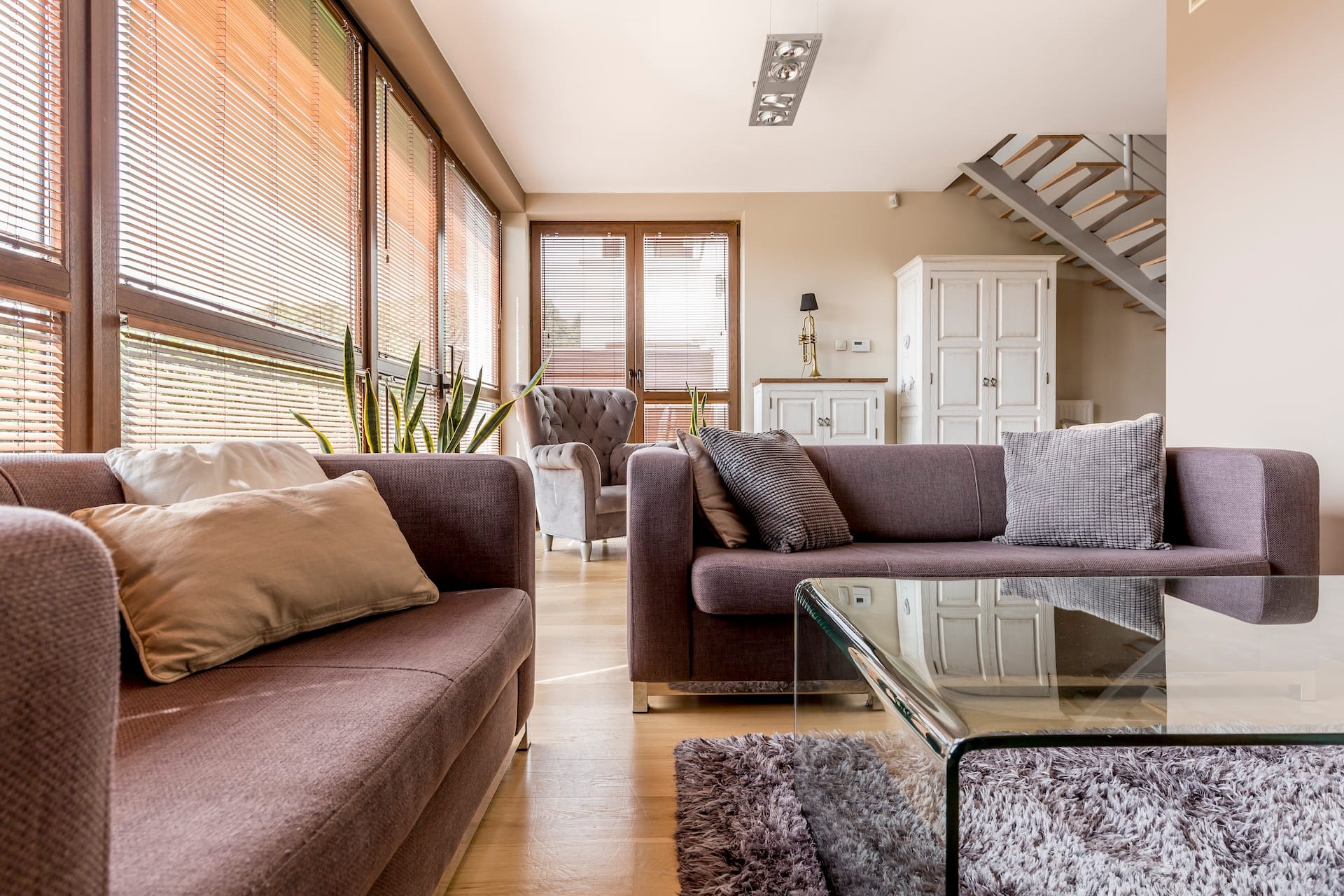 Bright grey living room with two couches and glass coffee table