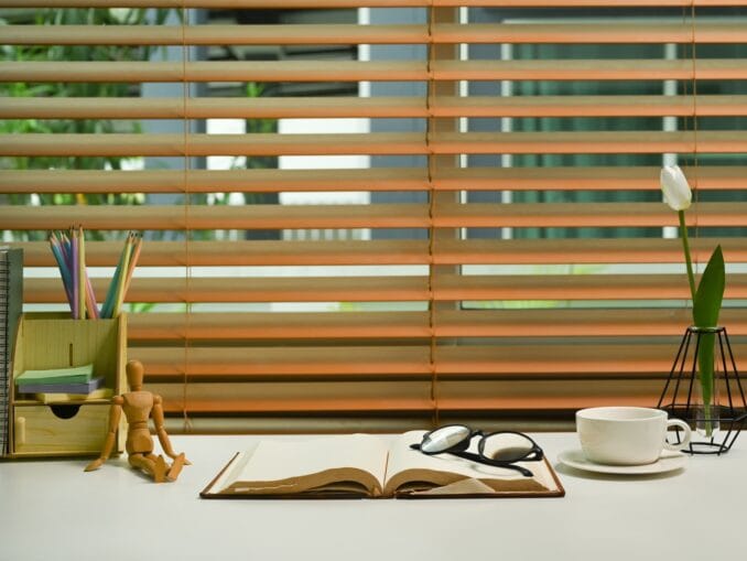 Home office desk with eyeglasses, books, coffee cup and supplies.